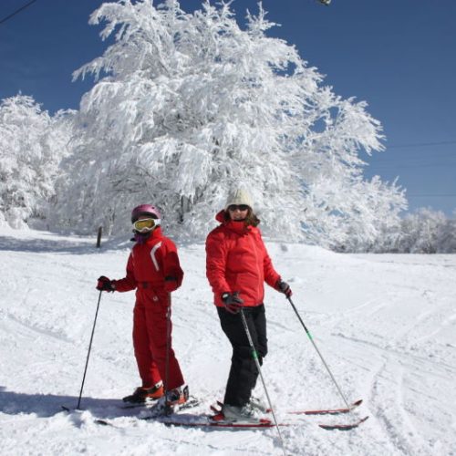 adulte et enfant sur piste de ski